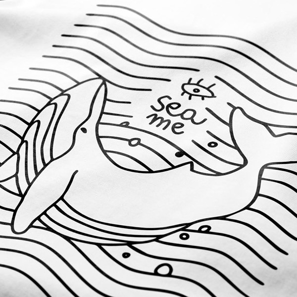 Nadruk flex na białej koszulce. Wieloryb w stylu lineart na tle równoległych do siebie fal. Nad nim napis SEA ME, pod spodem: "Keep oceans clean".